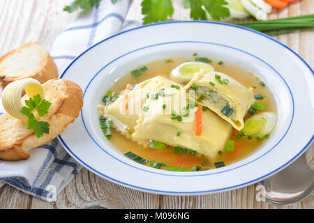 Avec le bouillon de légumes de style souabe ravioli farcis (qu'on appelle les «aultaschen') servi avec toast au beurre Banque D'Images
