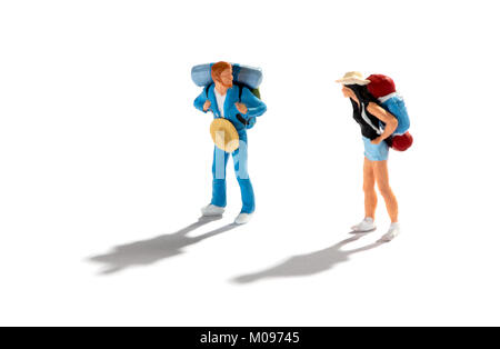 Figures miniatures de deux voyageurs routards ou sur un fond blanc avec ombre debout à l'un l'autre dans un concept de vacations, travel Banque D'Images