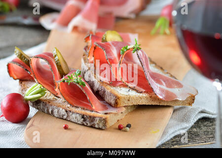 Tyrol du Sud lard fumé sur pain de campagne et un verre de vin rouge local Banque D'Images