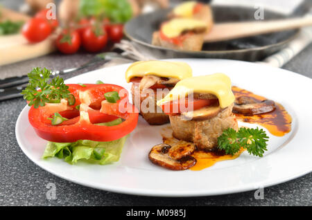 Filets de porc avec champignons, tomates et fromage fondu Banque D'Images