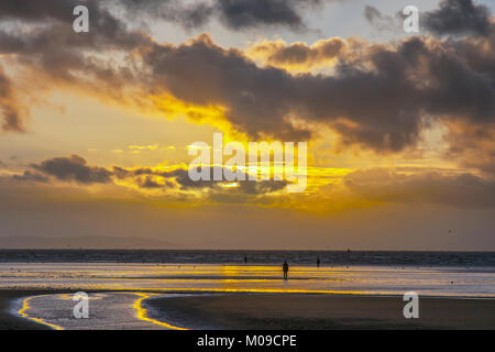 Un autre endroit, Sefton côte. Météo britannique. 19/01/2018. Ciel ensoleillé coloré sur l'estuaire de la Mersey comme le soleil couchers de soleil sur un jour froid et venteux hivers. Un autre endroit est une installation artistique sur la côte où 100 fonte spectaculaire, life-size chiffres par Antony Gormley, répartis sur trois mètres de l'estran et stretch près d'un kilomètre au large. /AlamyLiveNews MediaWorldImages Crédit : Banque D'Images
