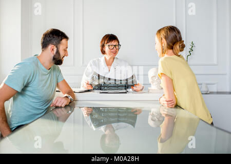 Jeune couple ayant une consultation avec le médecin senior Banque D'Images