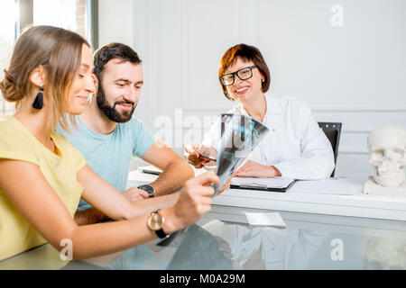 Jeune couple ayant une consultation avec le médecin senior Banque D'Images