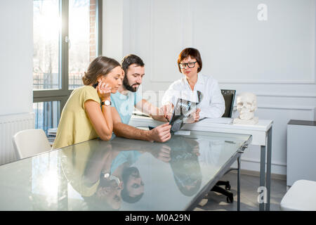 Jeune couple ayant une consultation avec le médecin senior Banque D'Images