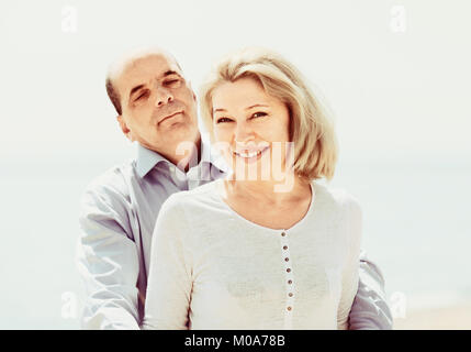 Vieux couple hugging on beach permanent Banque D'Images