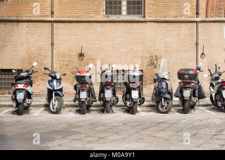 Une ligne de l'italien les cyclomoteurs, scooters et motos garées dans une ligne sur une rue de Bologne Italie.Une scène typiquement italien Banque D'Images