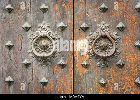 Deux anciennes heurtoirs de porte sur une ancienne porte dans Bologne Italie avec peeelng en laiton patiné et peinture. Banque D'Images