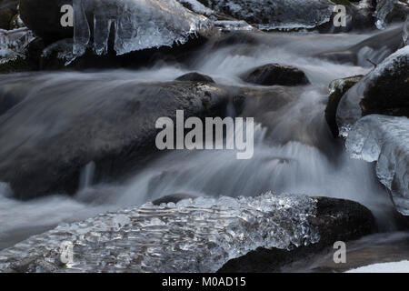 Froide journée d'hiver. L'écoulement de l'eau brouillée avec cascade, rochers dans un ruisseau ou un cours d'eau. Banque D'Images