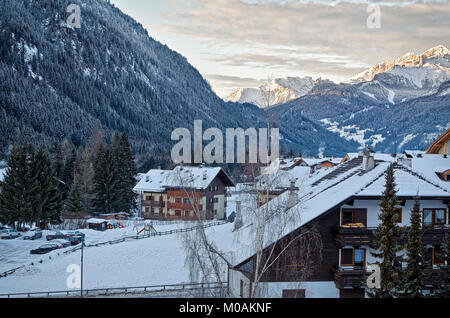 Afficher le long de la vallée au village de Campitello, avec des chalets et des pentes boisées de l'avant-plan, et le soleil attraper les montagnes au loin. Val Banque D'Images