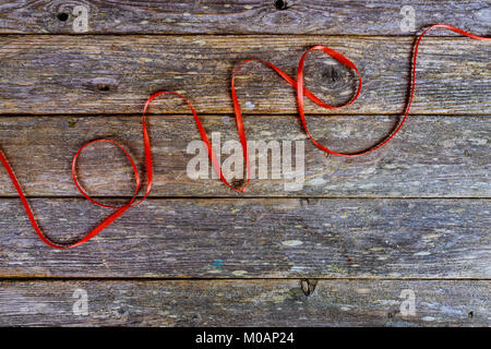 L'inscription de l'amour sur le fil de laine rouge ancienne en bois Banque D'Images