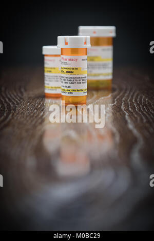 Variété de Non-Proprietary Prescription Medicine Bottles on Reflective Surface en bois. Banque D'Images