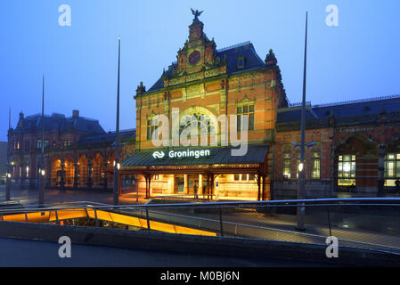 Groningen, Pays-Bas - 31 décembre 2016 : Les gens en face de la gare en soirée. L'actuel bâtiment de la gare a été conçue par Gosscha Izaak Banque D'Images