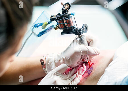 Le processus de création d'un tatouage sur le fémur libre. Pour les tatouages de la machine pendant le travail libre Banque D'Images