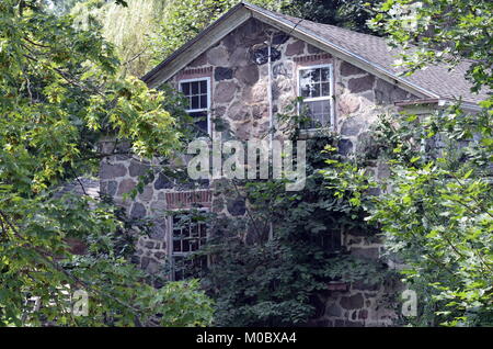 Ancienne maison de ferme de deux étages en pierre avec vignes grimpantes courir vers le haut l'avant de la maison Banque D'Images