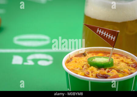 Gros plan macro de petit bol de chili et beer mug sur la table décorée pour grande partie de football Banque D'Images