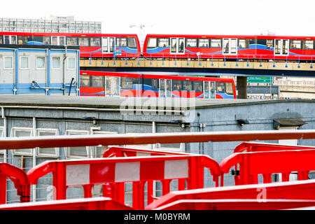 Deux trains qui franchissent l'un l'autre, vus à travers un chantier de construction à Canary Wharf, London Banque D'Images