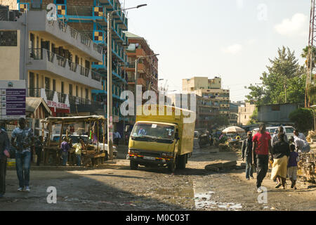 Vue vers le bas une route de Huruma, district de Nairobi, montrant un camion roulant sur la route boueuse, ainsi que les personnes et les bâtiments, Nairobi, Kenya, à l'est une Banque D'Images