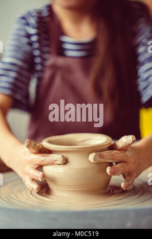 Mains de jeune potter, Close up fait mains cup sur roue de poterie Banque D'Images