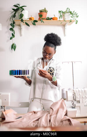 Couturière africaine holding bobines avec filetage Banque D'Images