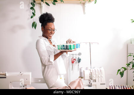 Couturière africaine holding bobines avec filetage Banque D'Images