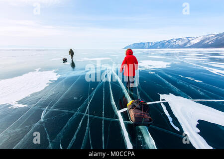Femme avec un traîneau à pied est sur la glace du lac Baïkal. Banque D'Images