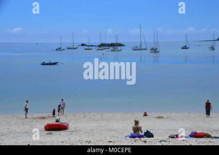 Les vacanciers à bronzer sur la plage de Porth Cressa Hugh Town, St Marys Island, Îles Scilly, Angleterre, Cornouailles, Royaume-Uni. Banque D'Images