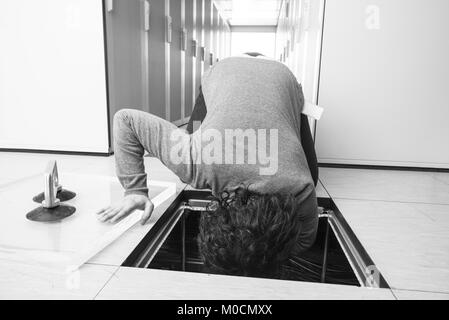 Jeune ingénieur connecter les câbles dans la salle serveur au centre de données moderne Banque D'Images