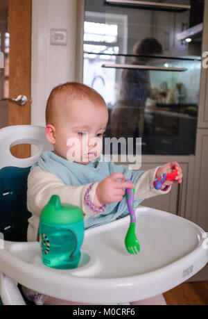 Jeune bébé 1 ans, fille, enfant de manger sain pour le dîner de légumes et des bâtonnets de poisson Banque D'Images