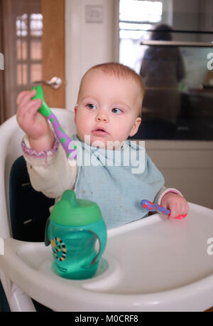 Jeune bébé 1 ans, fille, enfant de manger sain pour le dîner de légumes et des bâtonnets de poisson Banque D'Images