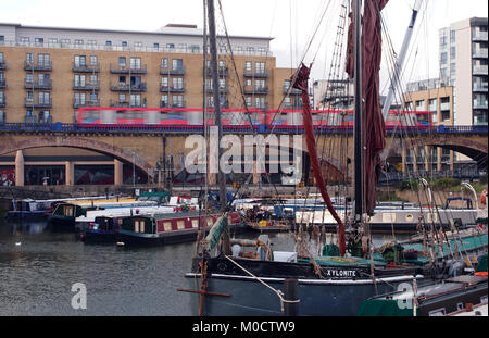 Une vue sur les péniches, bateaux et voiliers avec appartements résidentiels et la DLR avec un train de chemin de fer dans l'arrière-plan à Limehouse Basin, East London Banque D'Images