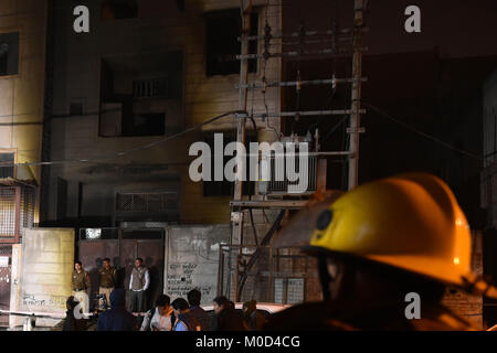 New Delhi. 20 Jan, 2018. Les gens se rassemblent à l'extérieur d'une usine de fabrication de biscuits où un incendie a éclaté à New Delhi, Inde, le 20 janvier 2018. Au moins 17 personnes sont mortes à New Delhi samedi soir lorsqu'un incendie éclate dans une usine de fabrication de biscuits dans la partie nord-ouest de la ville, les rapports des médias cité comme disant les agents du service d'incendie. Source : Xinhua/Alamy Live News Banque D'Images