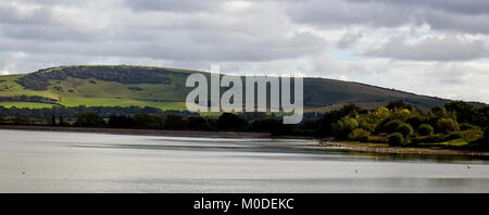 Le Long Man de Wilmington dans les South Downs au-delà du réservoir d'Arlington, près de Eastbourne, East Sussex, Angleterre, Royaume-Uni. Banque D'Images