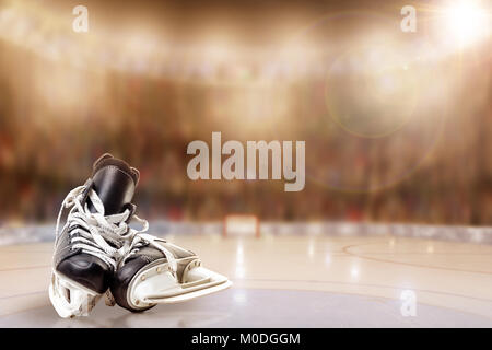 Low angle view de patins de hockey sur glace avec une faible profondeur de champ sur l'arrière-plan du stade bien éclairé et copier l'espace. Banque D'Images