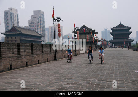 Les touristes chinois à vélo sur le mur de la ville de Xi'an avec une porte dans l'arrière-plan. Banque D'Images