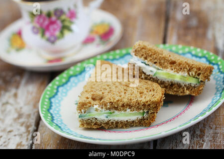 Le pain des sandwichs au fromage à la crème sur la plaque avec une tasse de thé dans la tasse vintage Banque D'Images