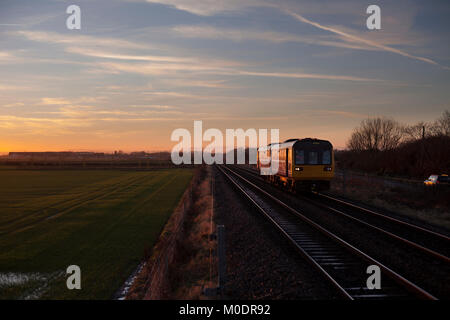 Un Northern rail train passe de stimulation avec un aéroport de Teesside Paris - Marseille service à coucher de soleil Banque D'Images