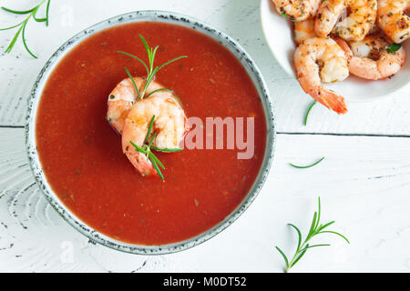 Gaspacho de légumes soupe de tomate aux crevettes (crevettes) et le romarin dans un bol blanc sur fond de bois, vue du dessus, copiez l'espace. Banque D'Images