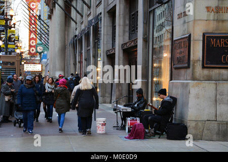 Blues des musiciens de rue de profiter d'un week-end d'hiver chaud et ensoleillé à confiture sur le trottoir de la rue de l'État pour les touristes au centre-ville de Chicago. Banque D'Images