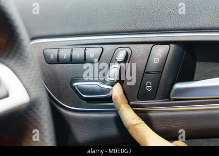 Part en appuyant sur le bouton de réglage pour le poste de président dans une voiture de luxe. Banque D'Images