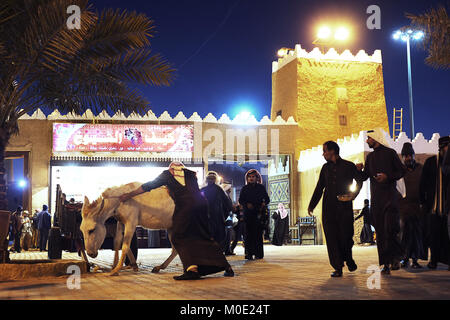 Un homme pousse un âne tout en fowrard montres foule lui à l'Al Janadriyadh Festival KSA Banque D'Images