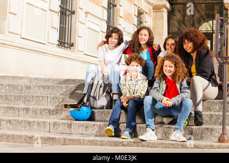 Les adolescents assis sur les marches à l'extérieur Banque D'Images