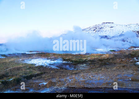 Un arrêt préféré le long du Golden Circle route pour les touristes en Islande est très active la zone du ressort de Geysir avec puits de boue bouillante, explosant les geysers et le quartier animé de Strokkur qui l'eau thermostatique 30 mètres (100 pi) dans l'air toutes les quelques minutes. En hiver, la région est encore très populaire la vapeur d'eau de geler sur place signifie que seuls les plus hardis s'asseoir pour regarder l'activité géothermique. Banque D'Images