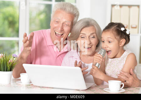 Les grands-parents et enfant chantant karaoké Banque D'Images