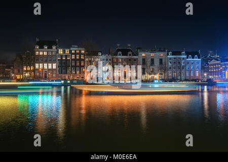 Amsterdam, Pays-Bas, le 16 décembre 2017 : la caractéristique des maisons du canal et péniches le long de la rivière Amstel, dans la vieille ville d'Amsterdam Banque D'Images