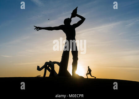 Las Palmas, Gran Canaria, Îles Canaries, Espagne. 21 janvier, 2018. Un jogger s'étend au lever du soleil dans le cadre de sculptures Triton avant le début de la Gran Canaria marathon dans la capitale, Las Palmas. Credit : ALAN DAWSON/Alamy Live News Banque D'Images