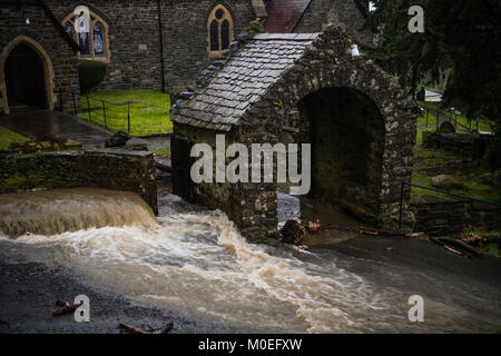 Llandre Ceredigion, pays de Galles, dimanche 21 janvier 2018 UK Weather : l'eau comme une rivière en cascade vers le bas de la rue principale de LLANDRE près d'Aberystwyth, au Pays de Galles, après des heures de pluies torrentielles ont occasionné la petite machine à vapeur qu'il traverse un village à l'éclatement spectaculaire de ses rives . Les résidents locaux faite de sable improvisé et les obstacles pour essayer de détourner l'eau loin de leurs maisons. Le ruisseau a débordé bien au-dessus du village juste à côté de l'église paroissiale, l'envoi vers le bas les débris et de laver certaines parties de la surface de la route Photo © Keith Morris / Alamy Live News Banque D'Images