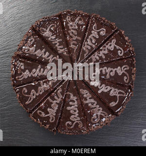 Gâteau au chocolat coupé en morceaux, sur fond noir. Banque D'Images