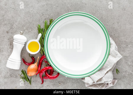 Contexte culinaire avec plaque vide et l'espace pour une mise à plat du texte, composition de l'huile, le piment, le romarin, l'oignon et d'épices sur une table sur la pierre Banque D'Images