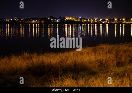 Soirée au lac salé de Larnaca, Chypre. Les lumières de la ville lumineuse sur le lac. Banque D'Images