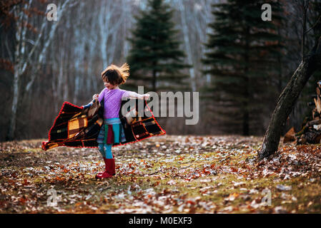 Girl enveloppé dans une couverture autour de la filature en forêt Banque D'Images